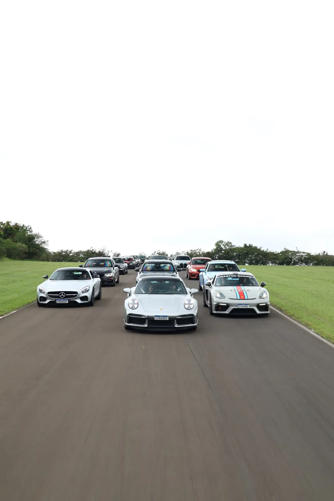 Porsche 911 Turbo S liderando o comboio ao lado do AMG GT e do Cayman Martini
