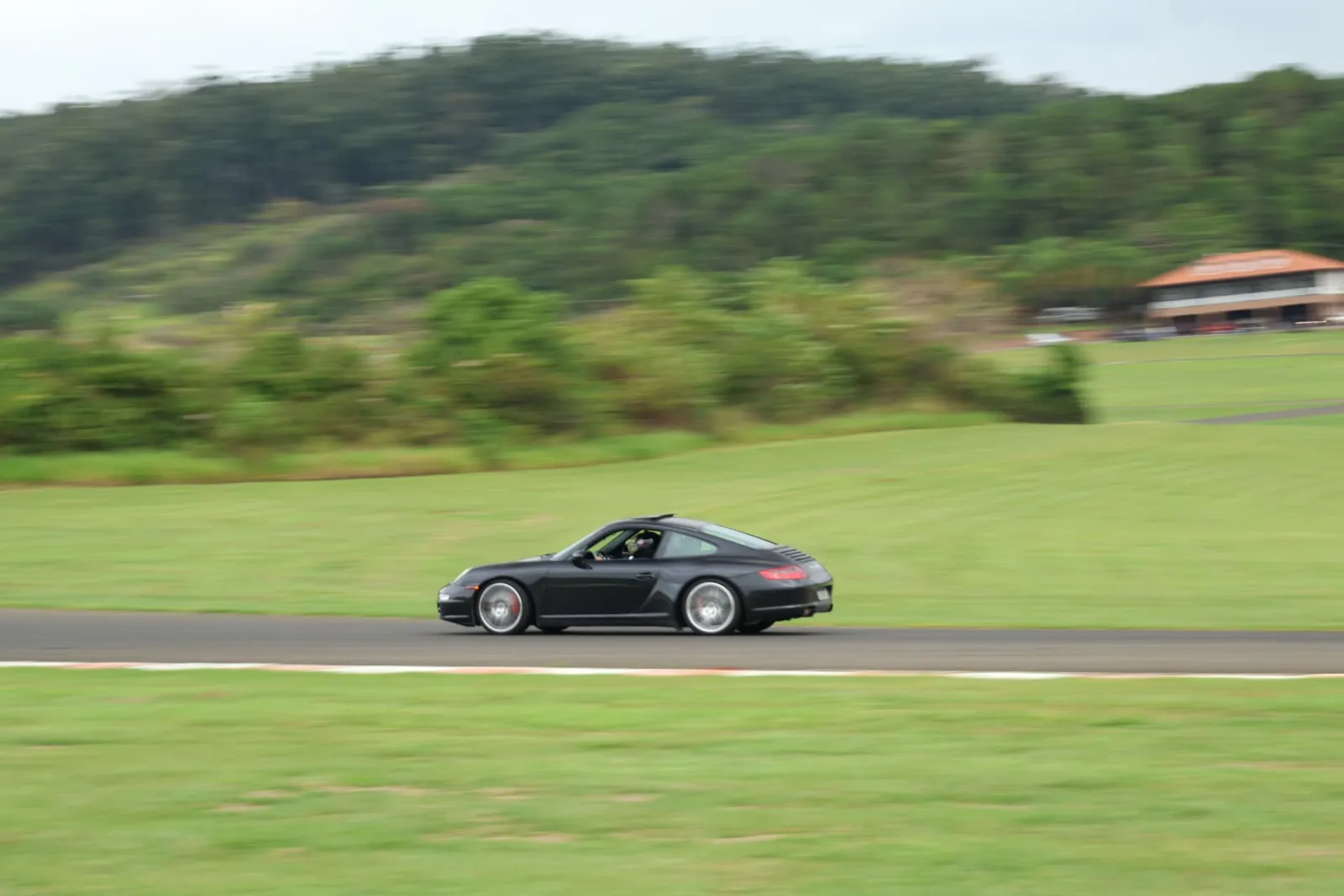 Porsche 911 Carrera preto em velocidade na reta