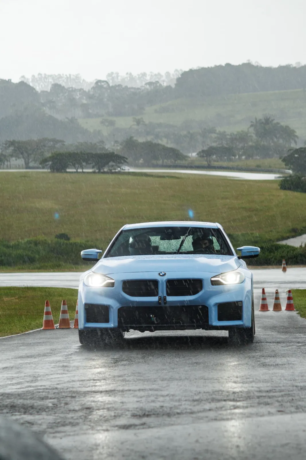 BMW M2 azul no slalom sob chuva