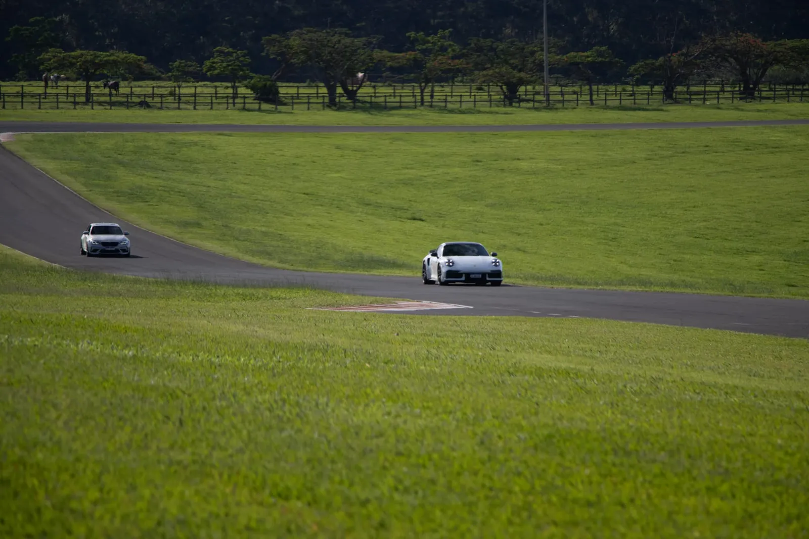 Porsche 911 e BMW M2 contornando a pista