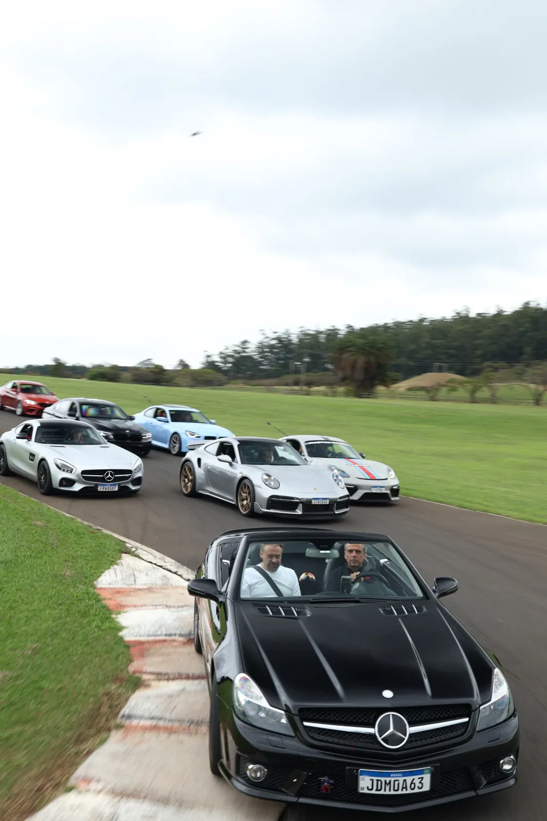 Mercedes SL 63 raspando a zebra à frente do comboio