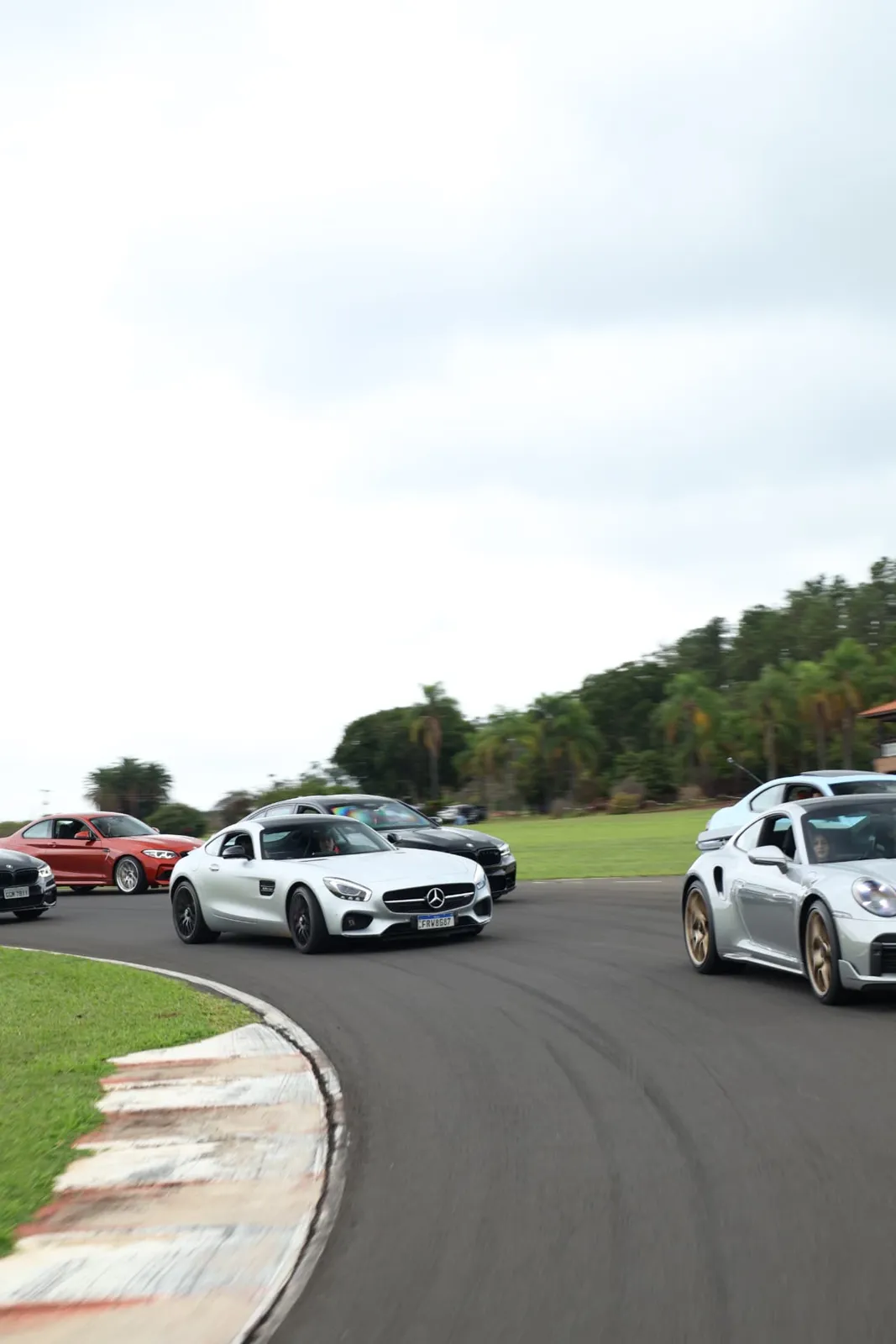 Comboio contornando a curva com o AMG GT ao centro