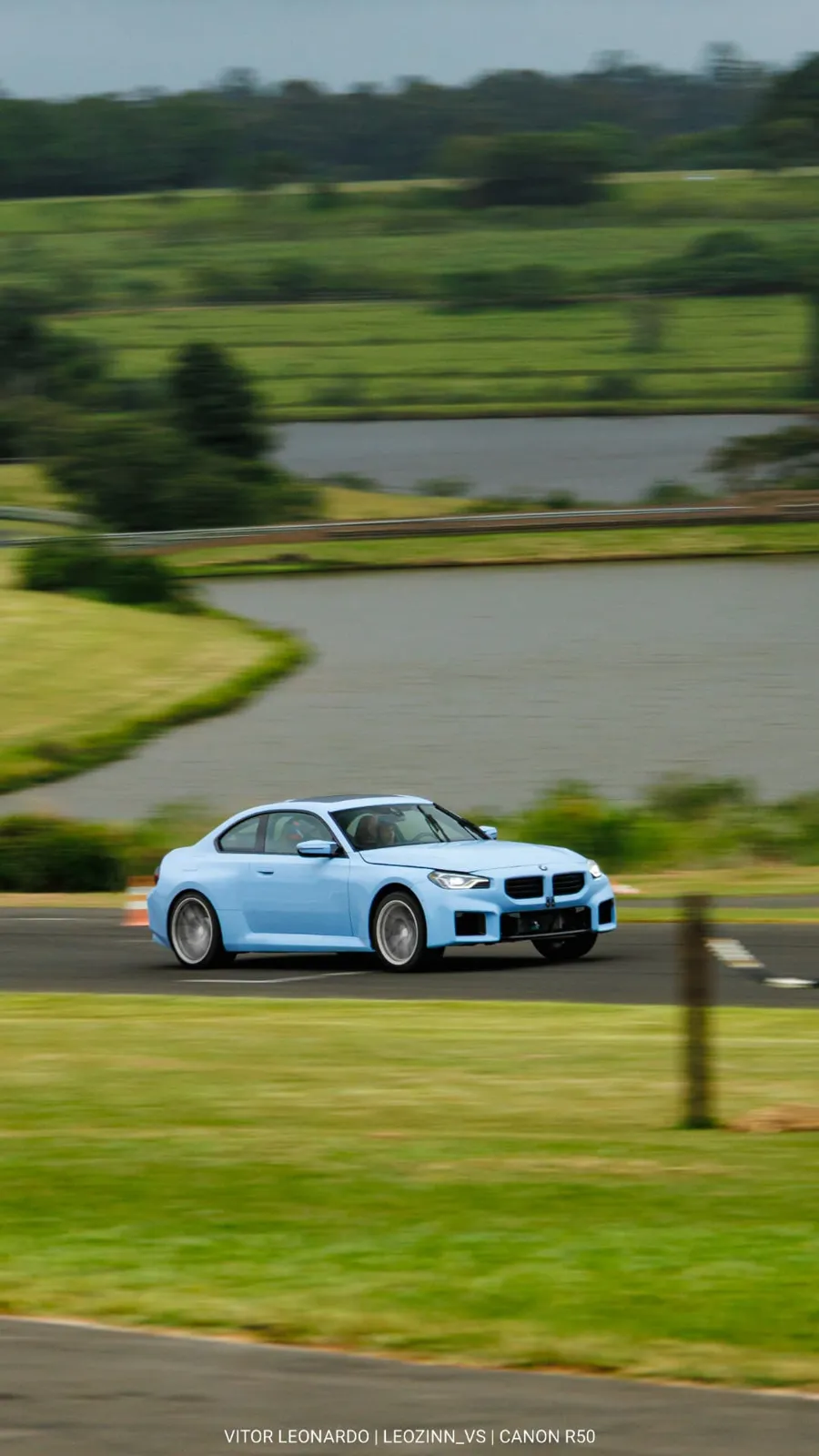 BMW M2 azul em velocidade com o lago ao fundo