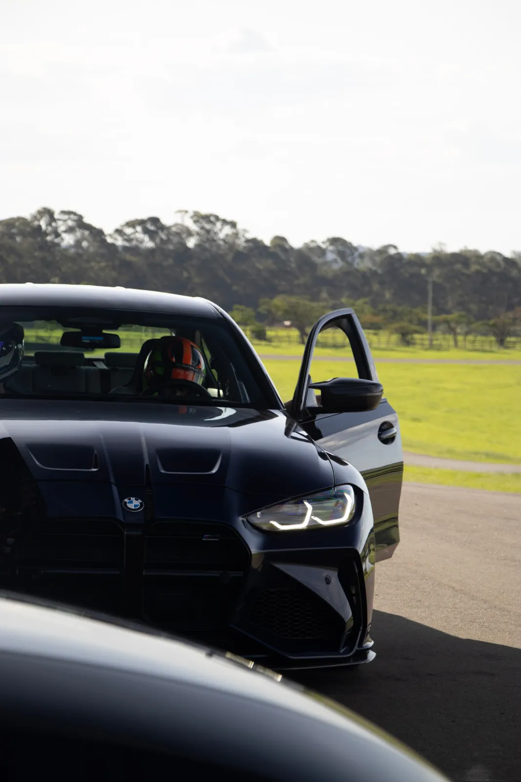 Piloto de capacete dentro do BMW M3 preto
