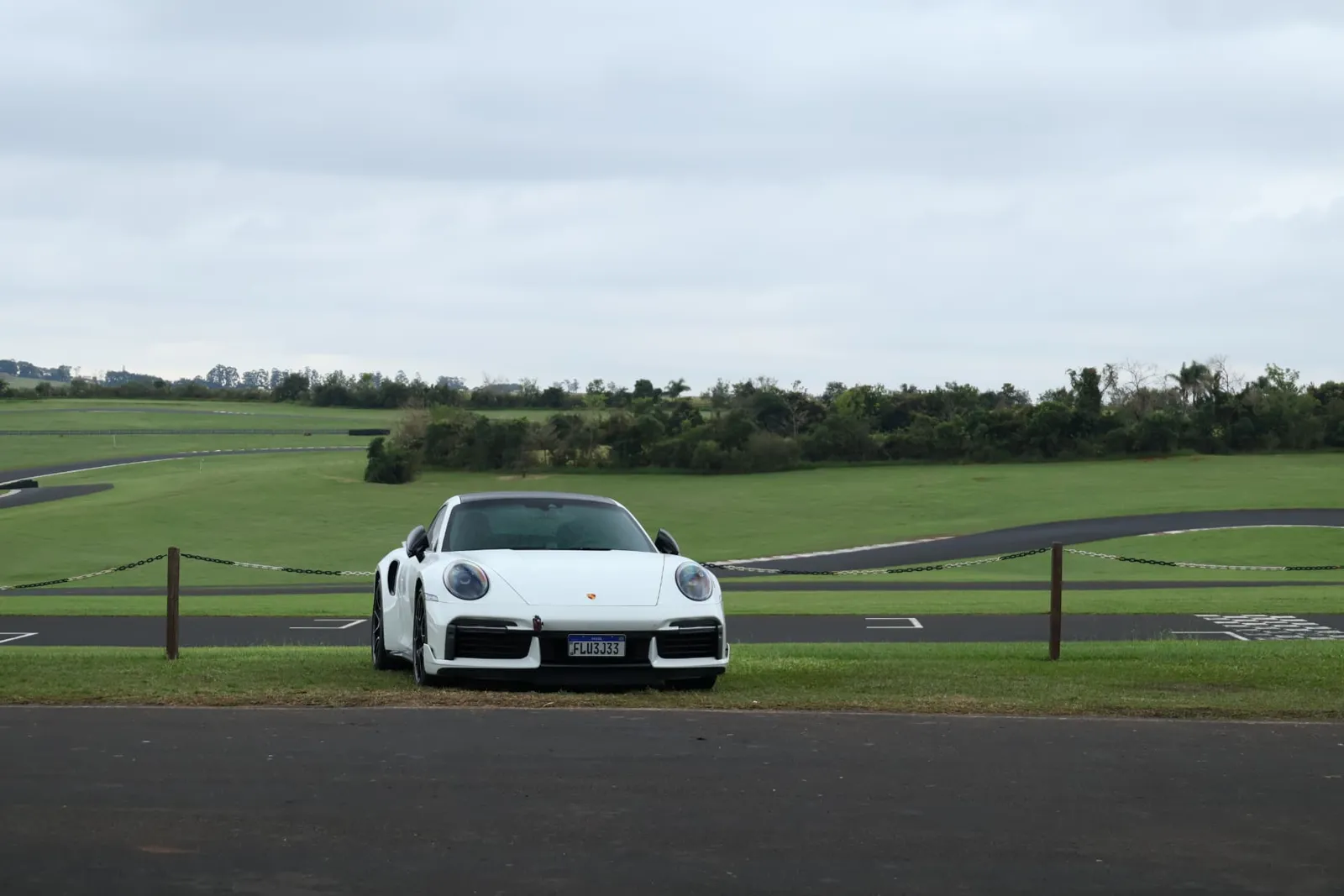 Porsche 911 Turbo S branco estacionado diante do traçado