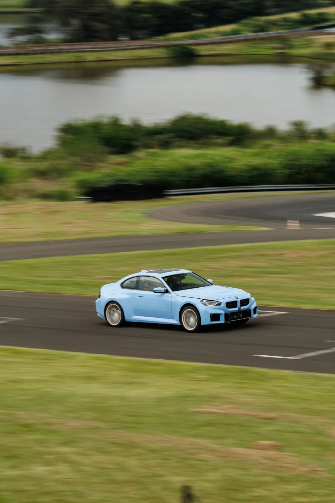 BMW M2 azul na pista com o lago ao fundo