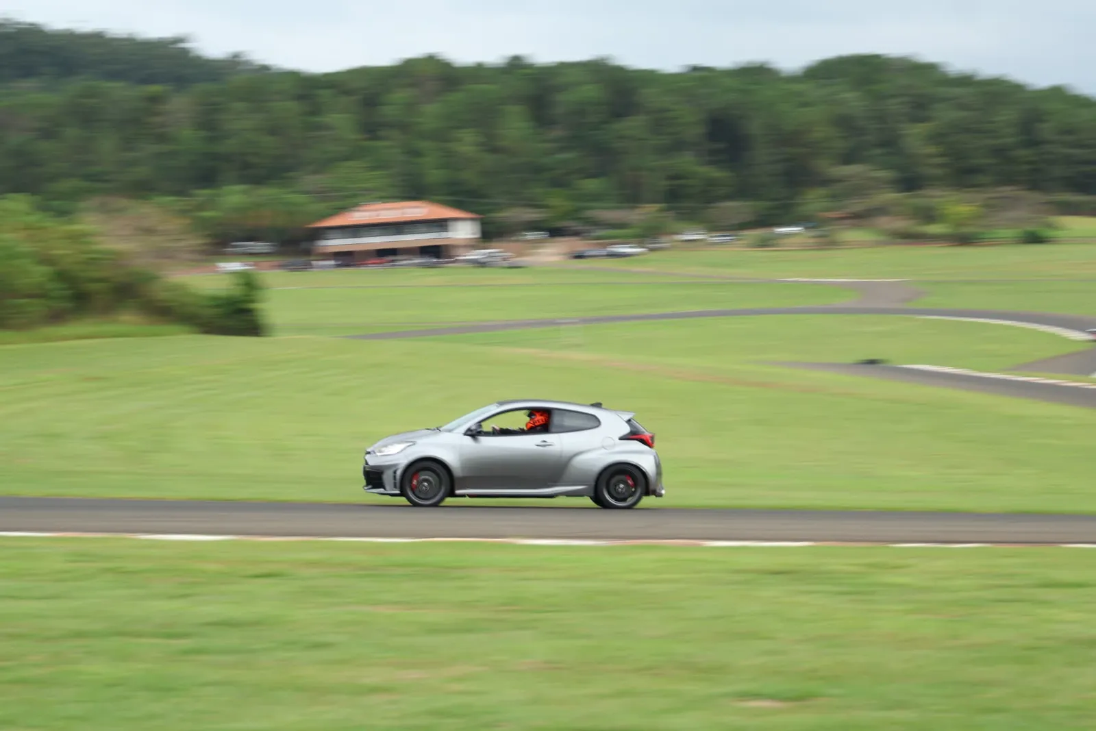 Toyota GR Yaris em velocidade com a sede ao fundo
