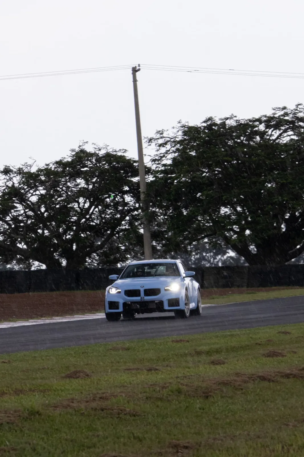 BMW M2 azul na pista sob chuva