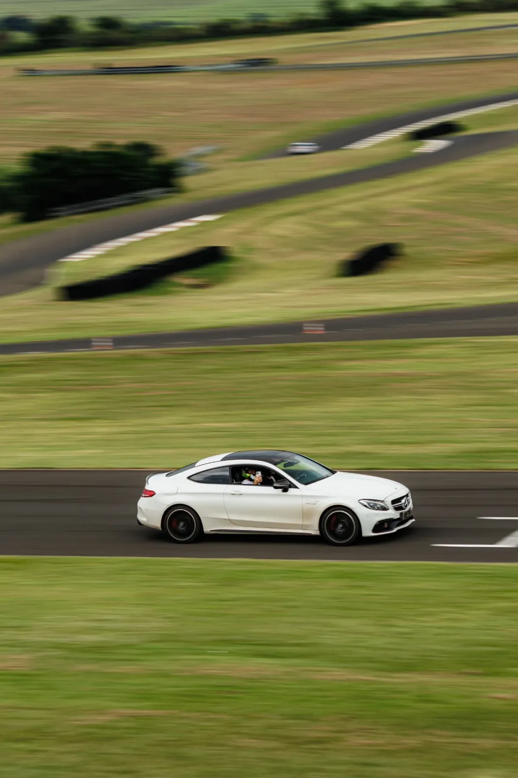 Mercedes-AMG C63 Coupé branco em velocidade na pista
