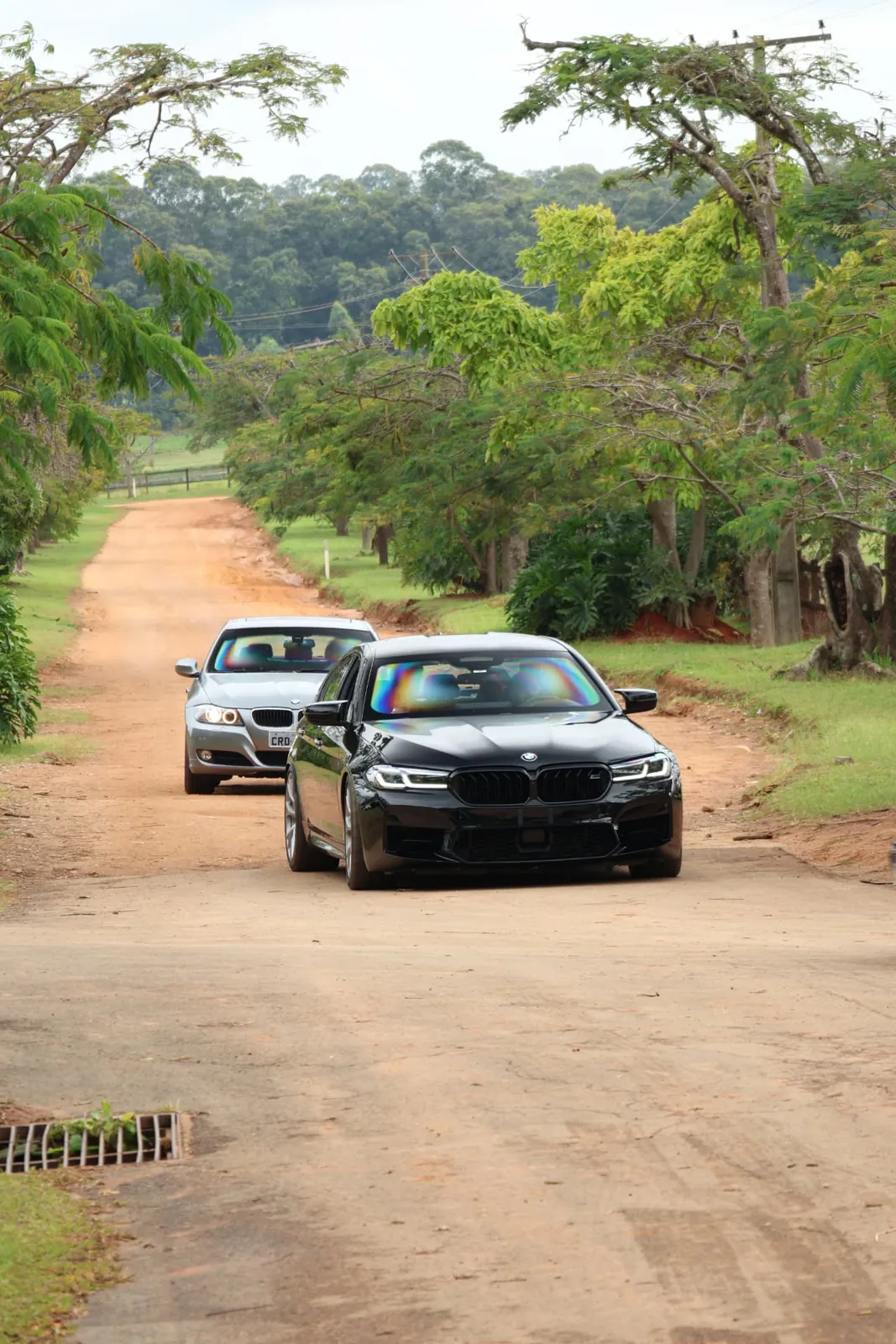 BMW M5 e BMW Série 3 chegando pela estrada de terra da fazenda