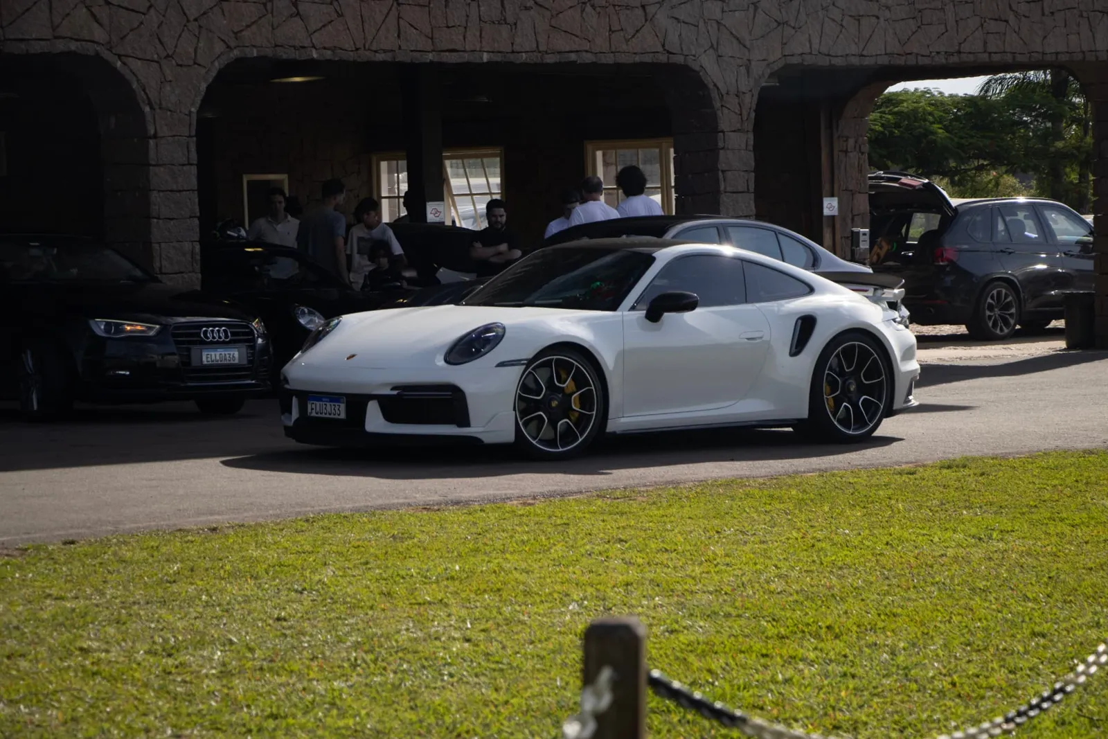 Porsche 911 Turbo branco em frente à sede