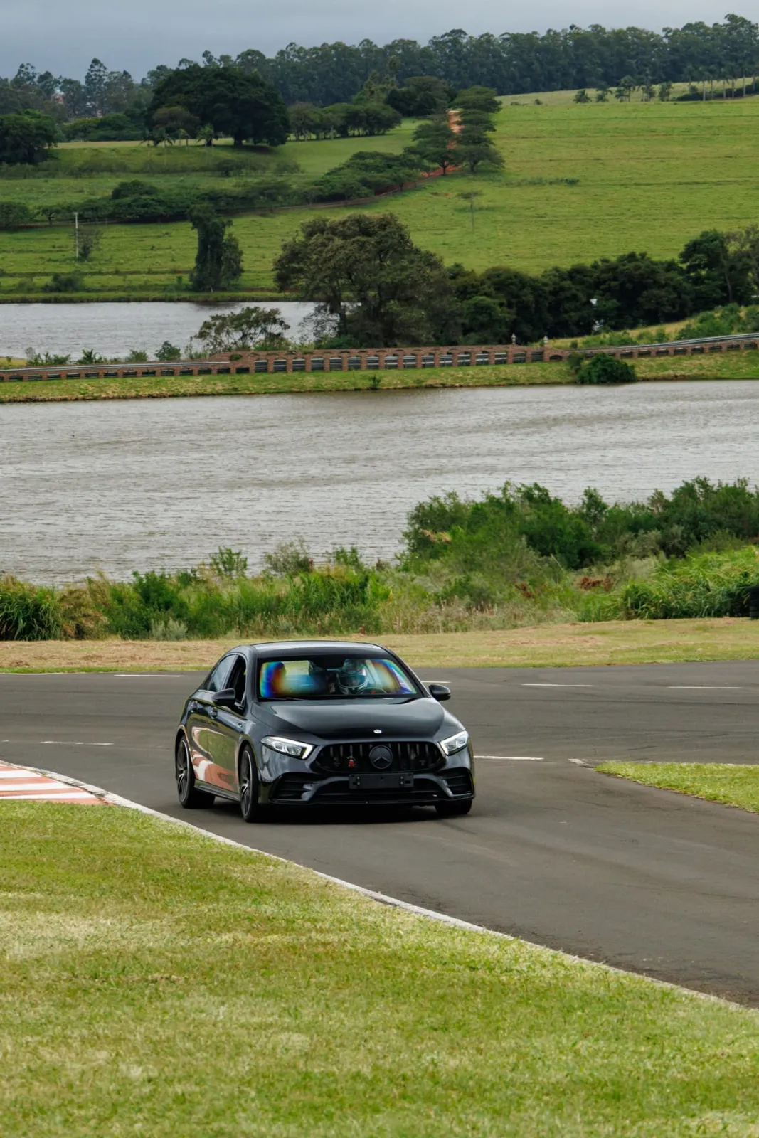 Mercedes-AMG A45 preto na pista com o lago ao fundo