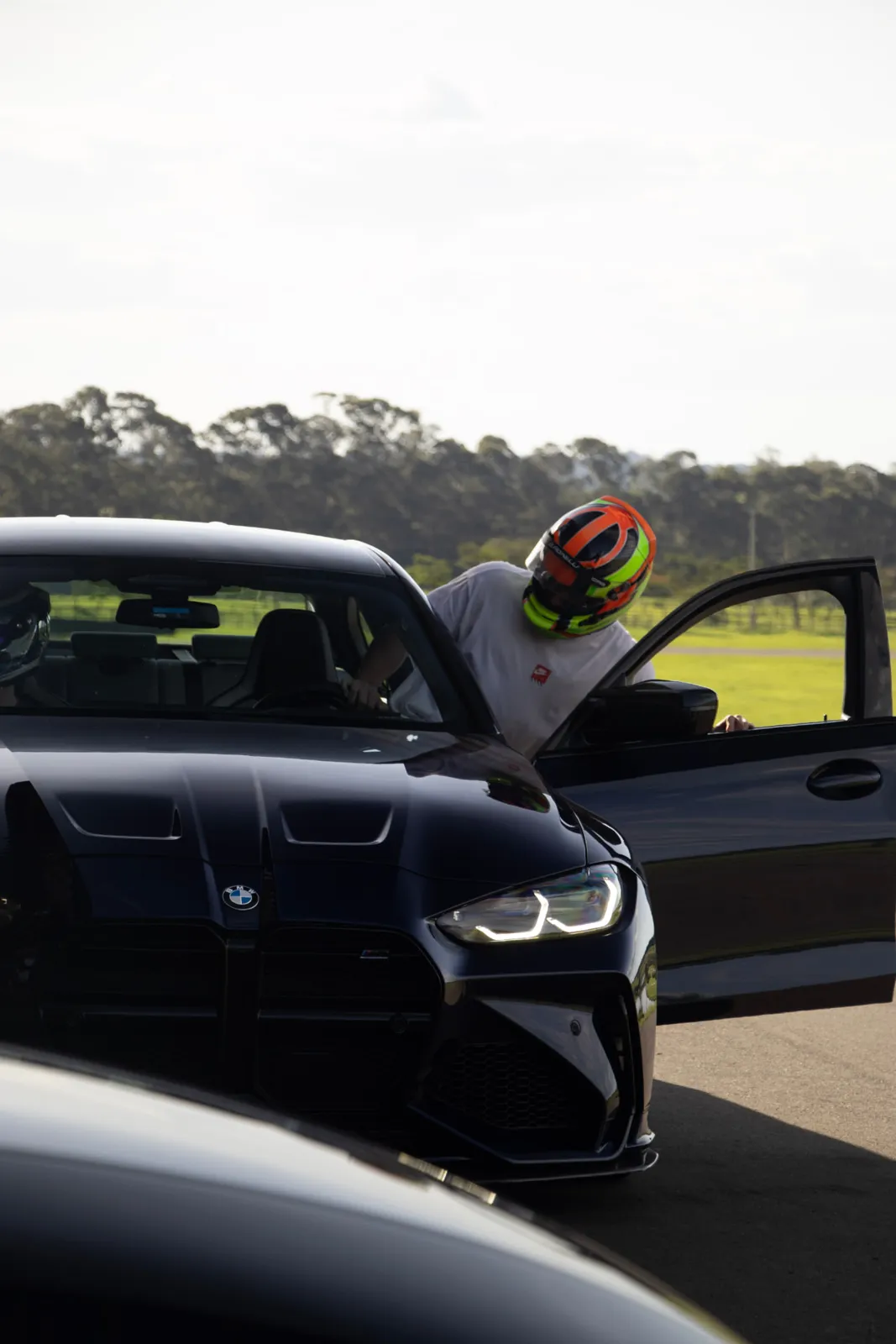 Piloto entrando no BMW M3 preto