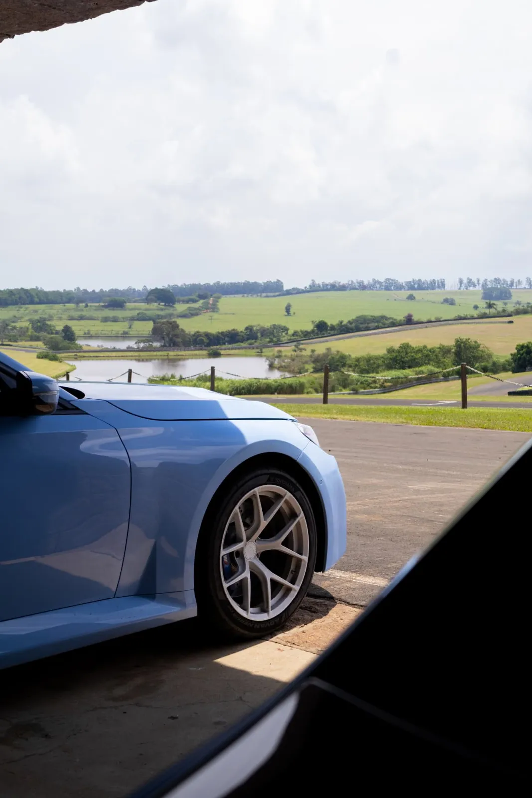 BMW M2 azul com vista para o lago e a pista