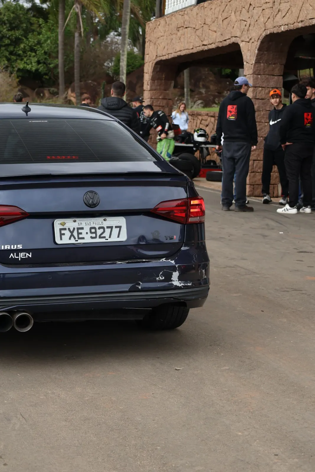 Traseira do Volkswagen Virtus nos boxes com pilotos ao fundo