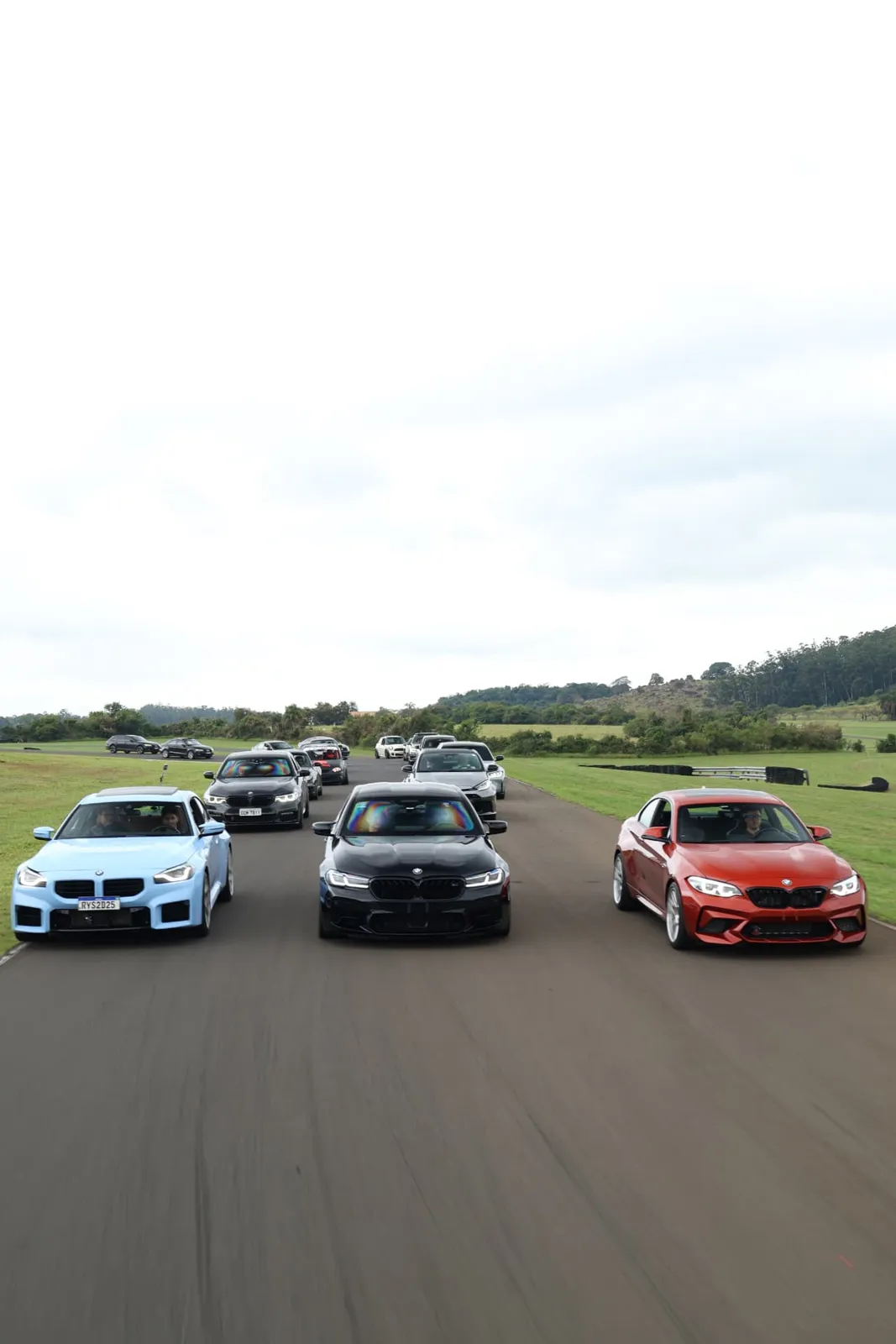 BMW M2 azul, M5 e M2 Competition lado a lado na reta