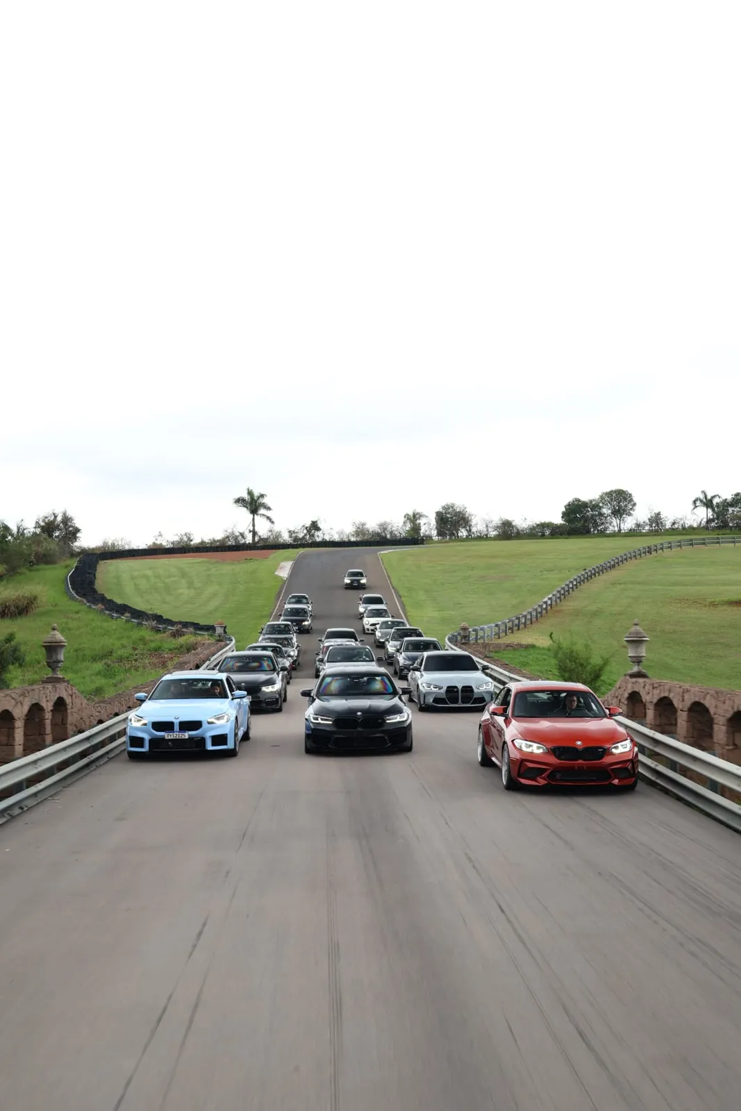 Comboio de BMWs cruzando a ponte de pedra do autódromo