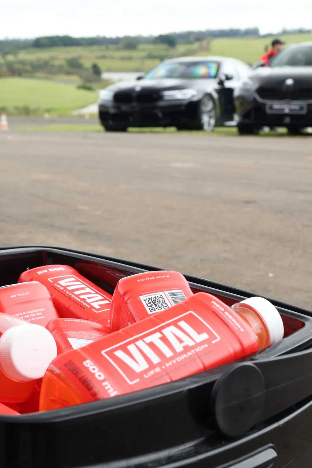 Garrafas de Vital Hydration com carros ao fundo