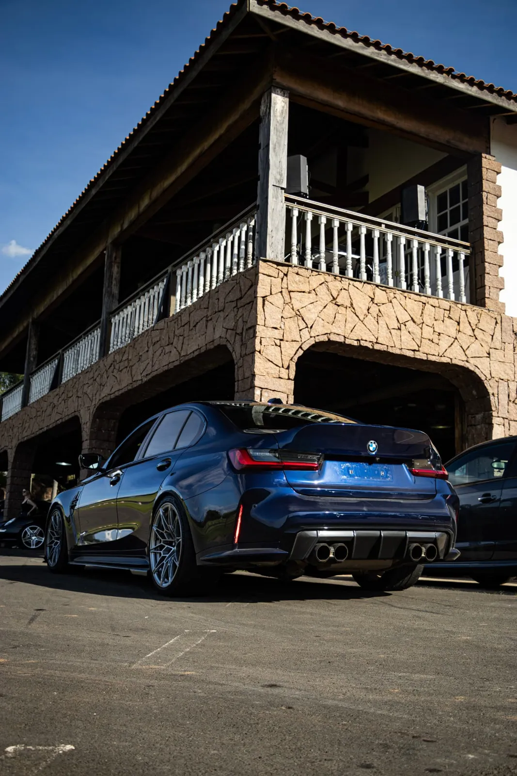 Traseira do BMW M3 azul em frente à sede do autódromo