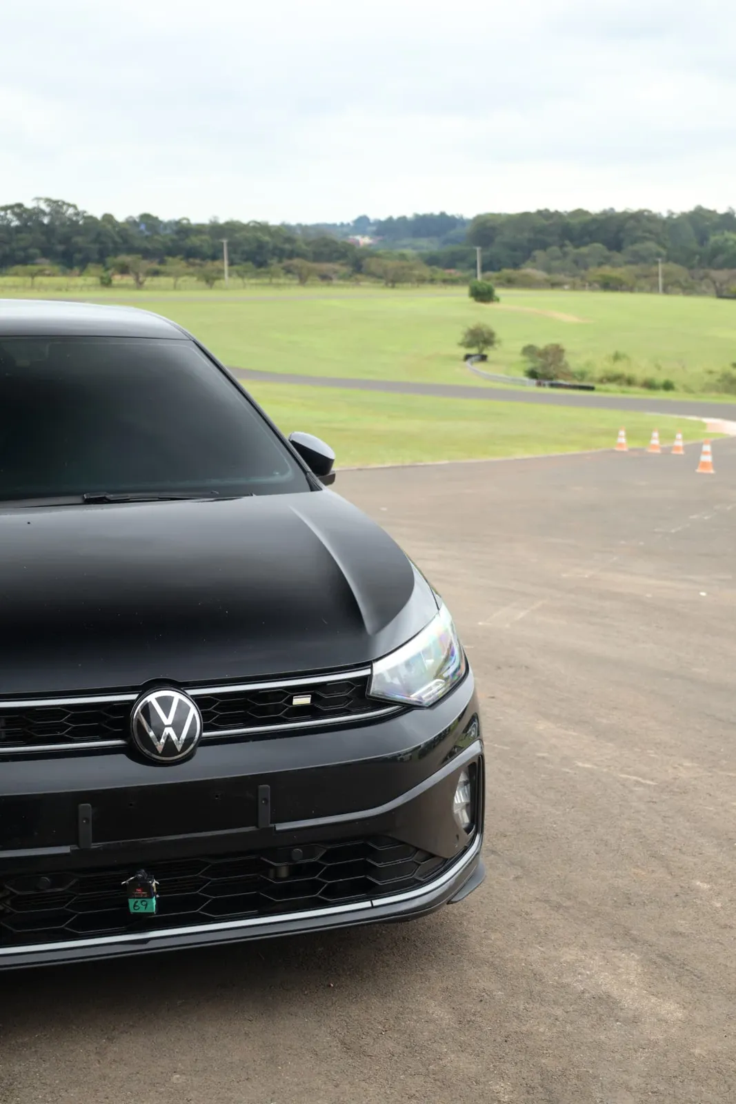 Frente do Volkswagen Virtus preto com a pista ao fundo