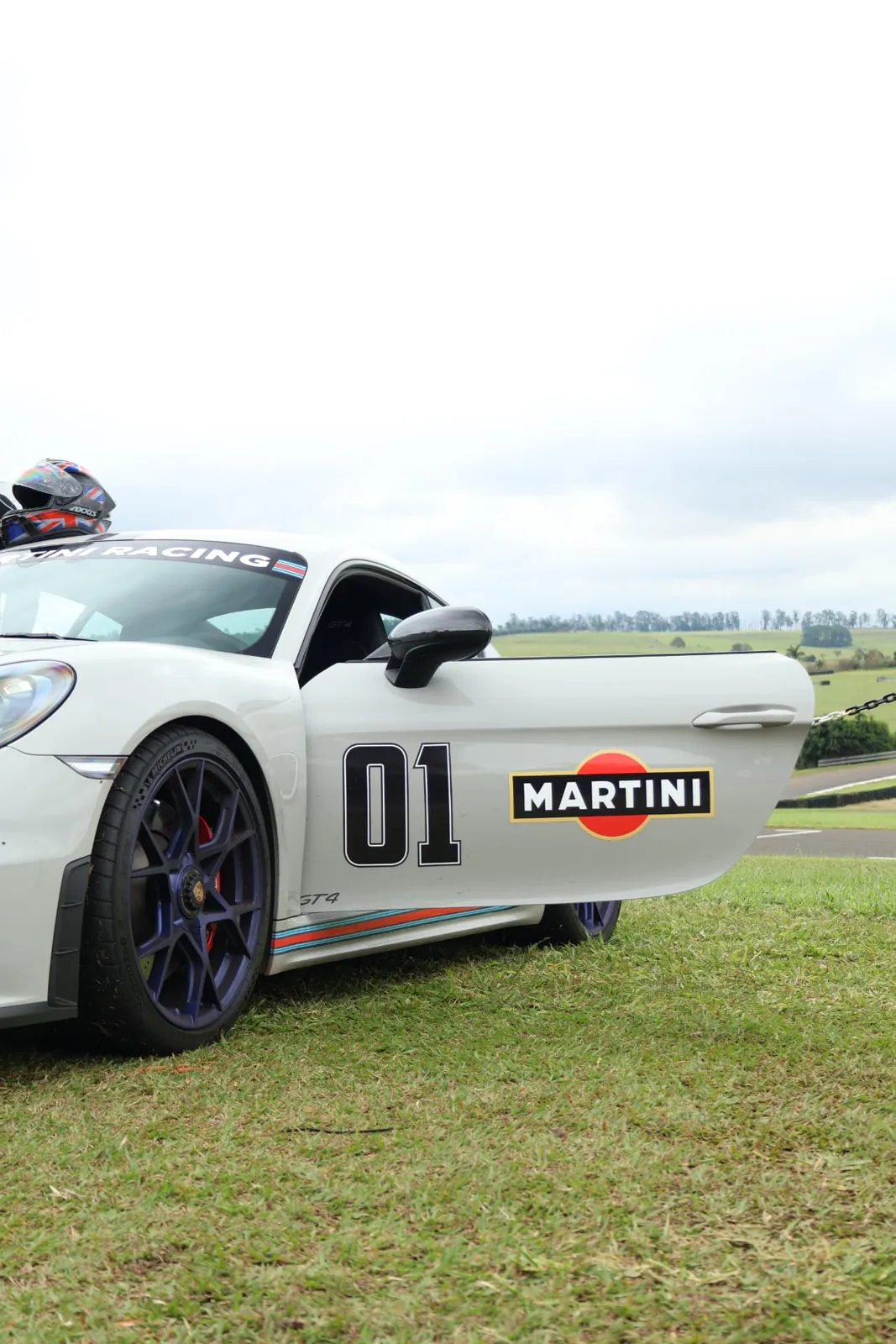 Porsche Cayman GT4 Martini com a porta aberta no gramado