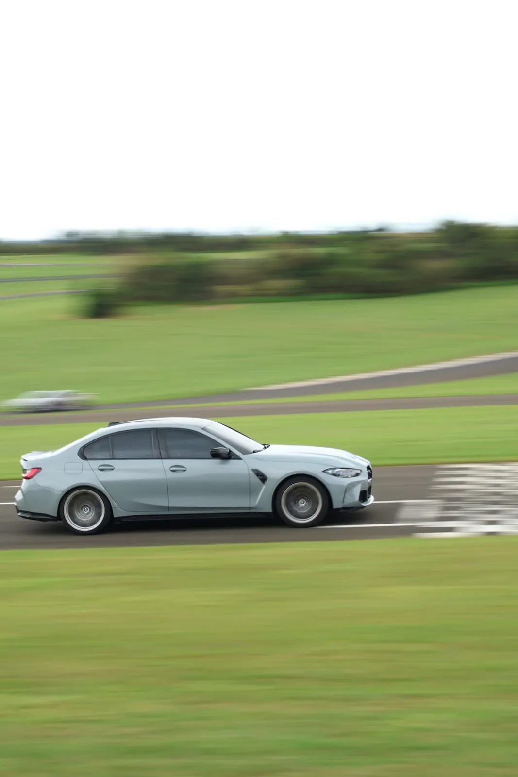 BMW M3 cinza passando pela faixa quadriculada
